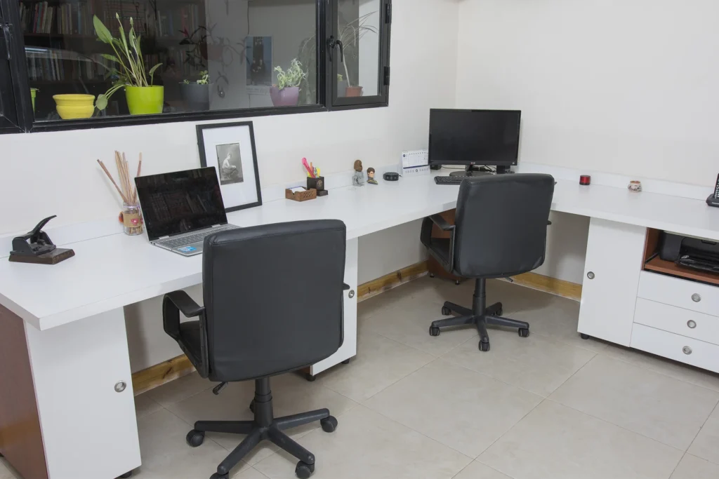 escritorio con 2 sillas y computadoras
